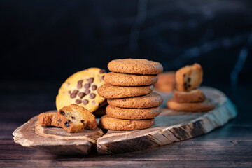 Homemade cookies with chocolate and nuts on a wooden table with a background blur.