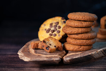 Homemade cookies with chocolate and nuts on a wooden table with a background blur.