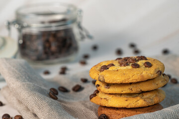 Homemade cookies with chocolate, nuts and coffee beans on a white background with a linen napkin with a background blur.