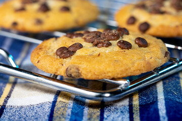 Homemade cookies with chocolate and nuts on a blue napkin with background blur.