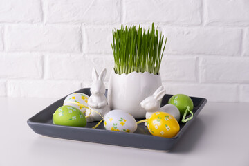 Home easter decor. Green oats, decorative rabbits and eggs