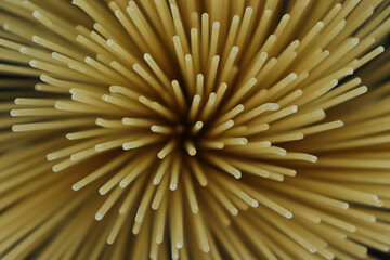 Dry spaghetti on black background from above