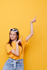 young beautiful woman fashion in yellow t-shirt denim shorts yellow background