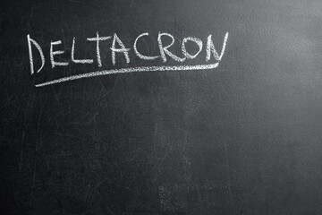 Fototapeta premium Deltacron inscription made with chalk on a black board. Blank space to insert text. Deltacron is a new version of Covid-19.