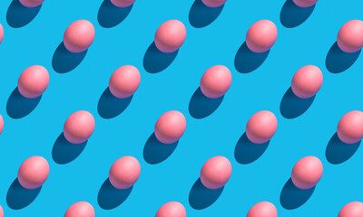 The pattern of their pink eggs with a hard shadow on a blue background. Minimalistic abstract Easter background.