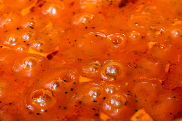 Kochende rote Tomaten-Sauce (für Nudeln) blubbert bei der Zubereitung in der Küche in einem Topf...