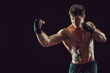 Portrait of aggressive boxer who training and practicing uppercut on black background. Sport concept - obrazy, fototapety, plakaty