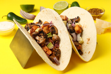 Concept of tasty food with taco on yellow background