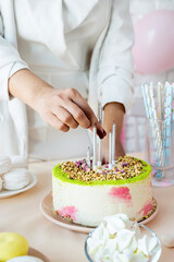 Woman in white party clothes preparing birthday table