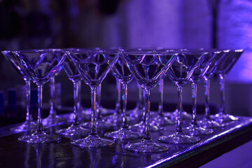 empty martini and cocktail glasses in neon light