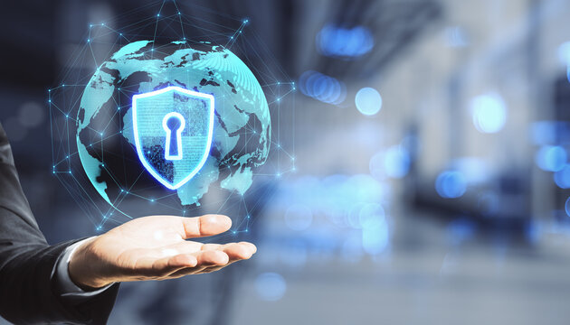 Close up of hand holding abstract glowing globe hologram with security shield icon on blurry office interior room bokeh background with mock up place. Protection, data and technology concept. - Powered by Adobe