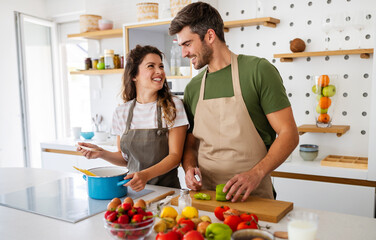 Happy young couple have fun in kitchen while preparing healthy organic food