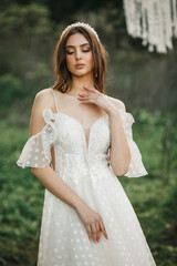 A young cute girl in a white dress poses beautifully. Positive attitude