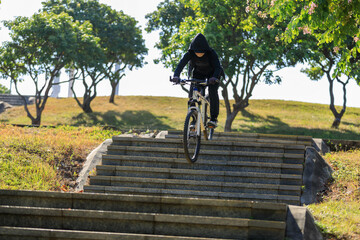 Woman free rider riding bike going down city stairs