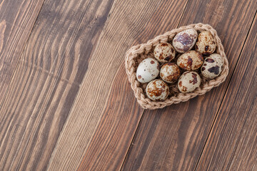 Group of quail eggs are put on clear tray on wooden table.