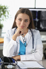 Portrait of woman doctor with glasses in her hands in clinic office