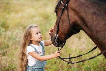 Friendship of a child with a horse. Treating autism with a horse. Interaction of a girl with autism...