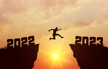 Fototapeta A young silhouette man jump between 2022 and 2023 years over the sun and through on the gap of hill evening sky. Business concept. Welcome Happy New Year 2023. Vector illustration. obraz