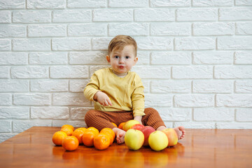 Smiling child eats one fresh juicy red apple. Healthy fruits for young children. The child eats fruits and vegetables.