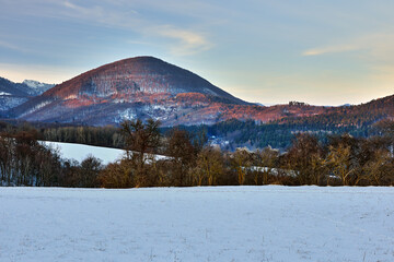 Mountain winter landscape at sunset. Side light. Beautiful hills and forest. Protected area  Vrsatec, Slovakia.