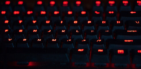 Obraz premium blacklit keyboard close up. gaming keyboard with black keys with iluminated characters. mechanical keyboard.