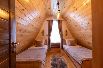 Interior of a wooden mountain house attic two bed bedroom
