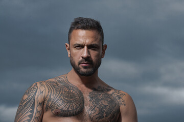 Portrait of handsome man with serious face. Bare strong naked torso.