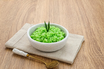 Tape Ketan Pandan is a typical Indonesian food made from fermented sticky rice. Served in small bowl. Selected focus.

