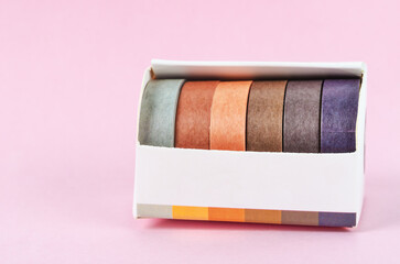 Collection of Colorful adhesive tape rolls in box.