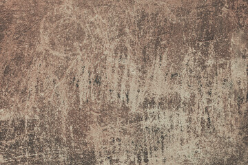 An old brown painted wall background. A plaster wall texture with rough scratches.