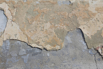 A concrete wall texture with cracked beige paint. An old grey cement wall background.