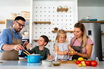 Happy family preparing healthy food together in kitchen