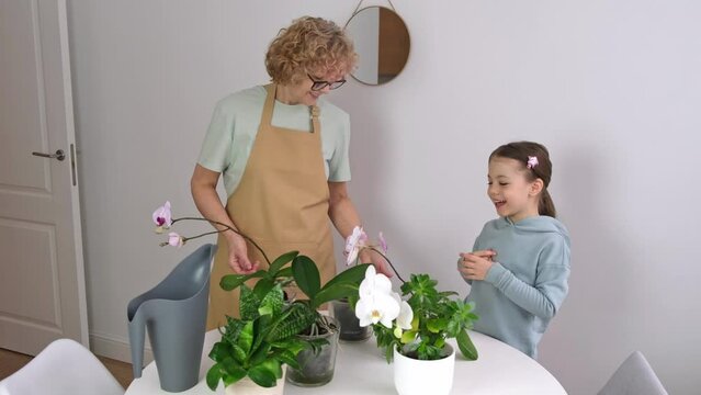 Senior Woman with child enjoy her orchids House Plants