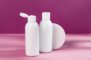 Skincare beauty cosmetic concept. White tube of cream lotion cleanser antioxidant facial oil on pink background