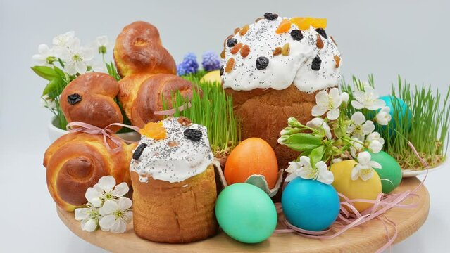 Festively decorated easter bunnies, eggs, easter, wheat sprouts on a rotating wooden surface, front view