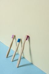 Toothbrushes leaning on colored background