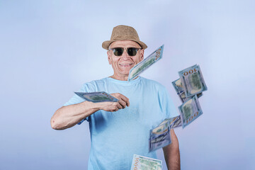 Portrait of funny old man millionaire in sunglasses waste money throw banknotes isolated over gray...
