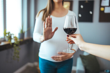 Pregnant woman refusing a glass of wine. Alcohol In Pregnancy. Unrecognizable Expectant Lady...