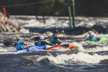 Kayak slalom canoe race in white water rapid river, process of kayaking competition with multiple colorful canoe kayak boat paddling, process of canoeing with big water splash