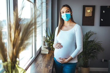 Pregnant women wear a protective mask to prevent germs. Look out of the window During the...