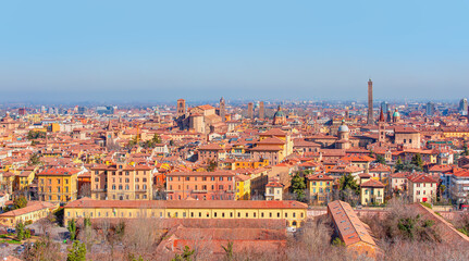 Fototapeta na wymiar Panoramic view of red rooftops and buildings - Cityscape from above, view of Garisenda and Asinelli tower - Bologna, Italy