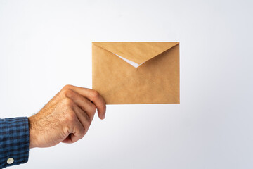 Male hand holding small envelope against the white surface