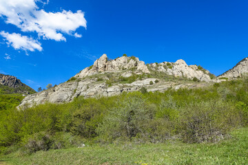 Ancient limestone high mountains of rounded shape in the air haze. The Valley of Ghosts. Demerji. Crimea.
