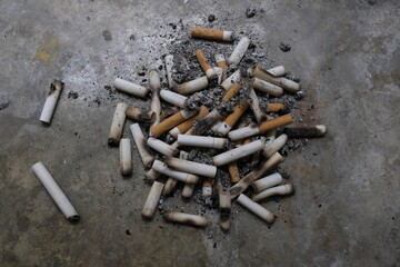 Closeup of cigarettes in the ground. Unhealthy cigarettes and nicotine. Smoking butts in garbage on...