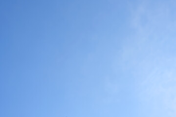 Tiny clouds against clear blue sky background.