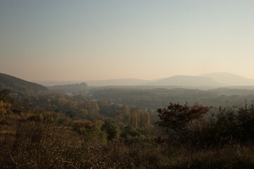 Hazy autumn sunset in the valley, panoramic view from hill on the autumn nature
