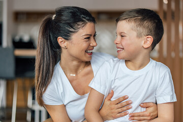 Mother's day, smiling caucasian mother, tickling her son, while he laughs.