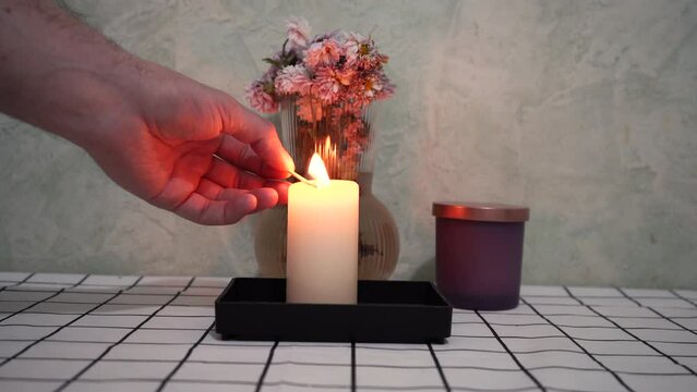 man lights a candle at the table