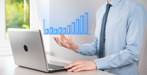 Business man holding tablet and showing holographic graphs and stock market statistics gain profits. Concept of growth planning and business strategy. Display of good economy form digital screen.