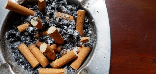 ashtray made of metal full of cigarette butts